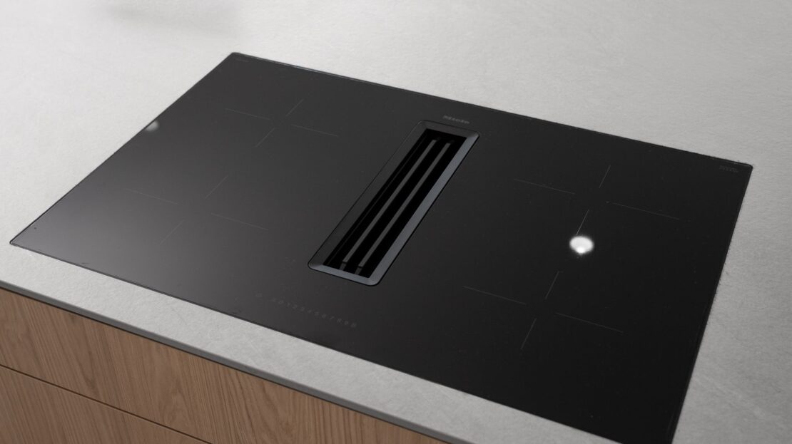 Ultra-thin electric cooktop with built-in downdraft extractor in Los Belvederes penthouse kitchen, Marbella luxury modern design