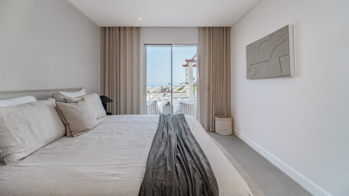Luxury king bedroom opening to private terrace with built-in seating in Los Belvederes penthouse, Marbella indoor-outdoor living
