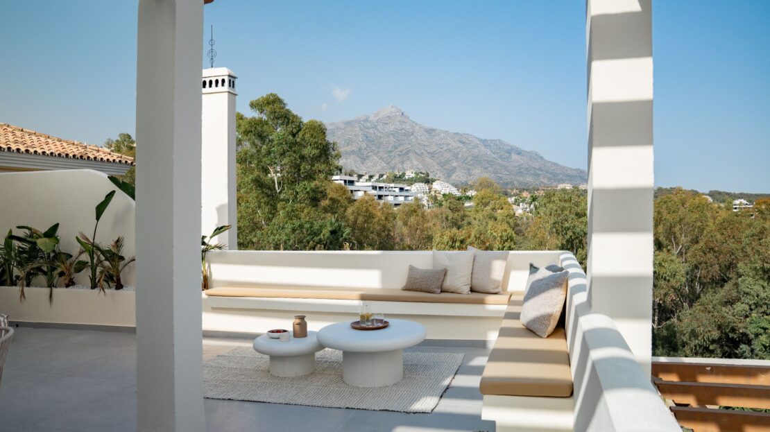 Luxury built-in corner seating with brown cushions against cream walls on Los Belvederes penthouse rooftop, Marbella outdoor living space
