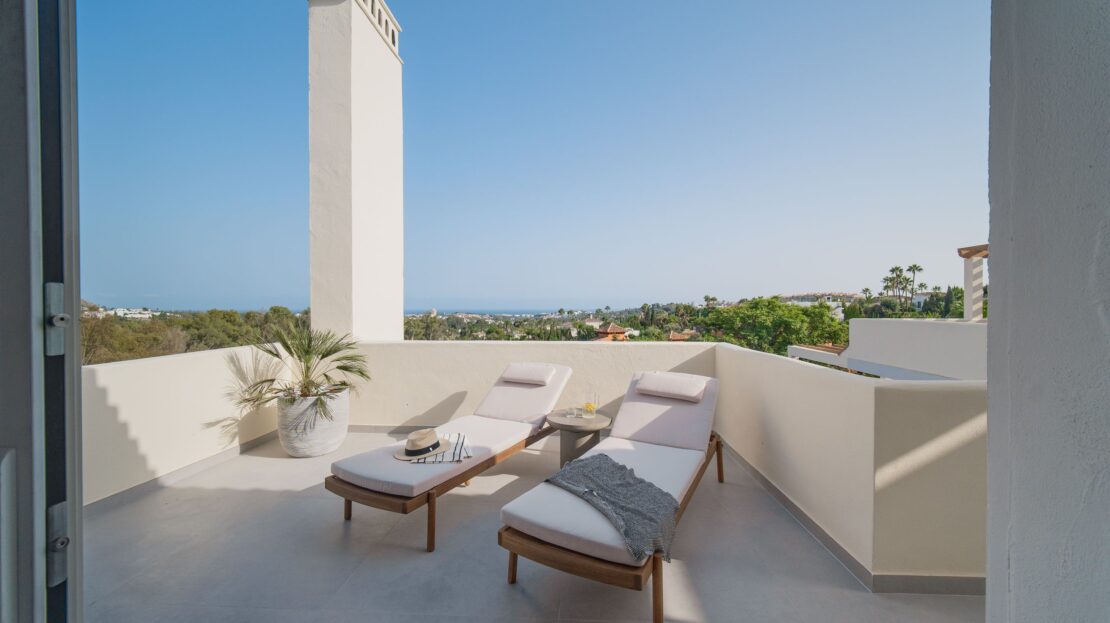 Two luxury sunbeds on private penthouse rooftop terrace overlooking Marbella's coastline and village views at Los Belvederes, Nueva Andalucía
