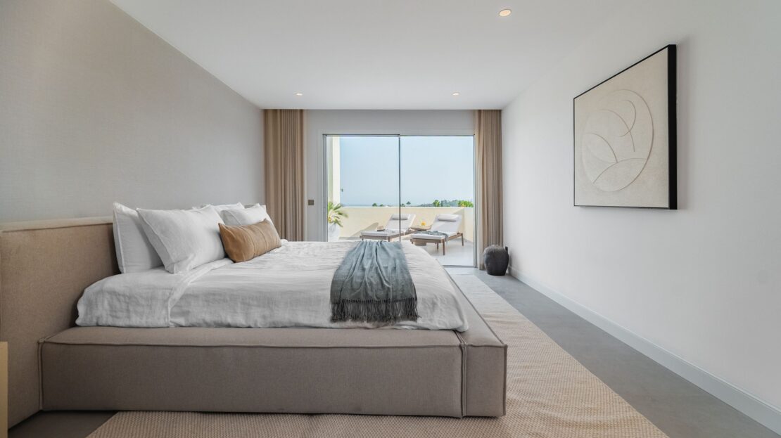 Close-up of premium king-sized bed with designer bedside lamps and high-end linens in Los Belvederes penthouse master bedroom, Marbella