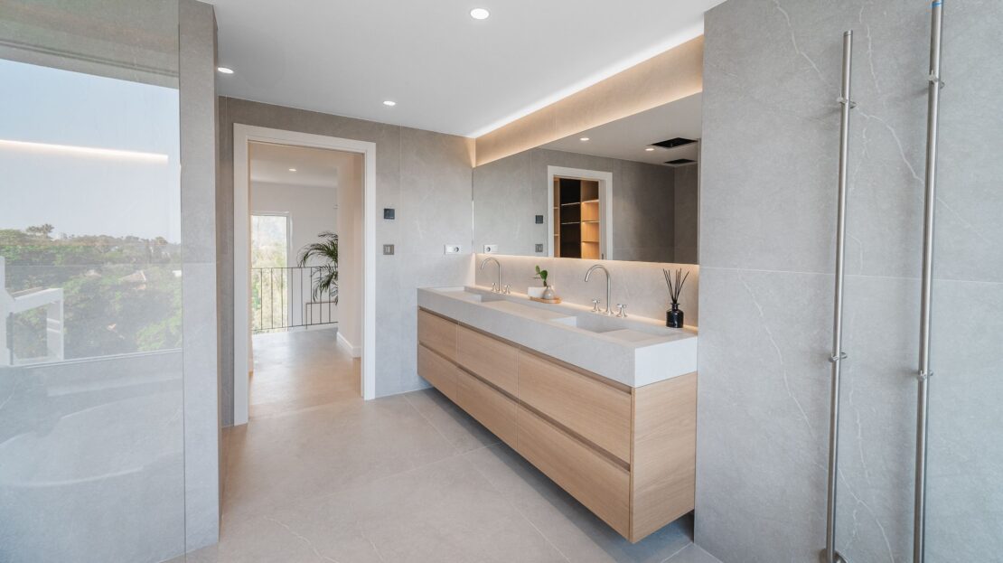 Elegant double vanity sinks with illuminated mirrors and spacious corridor in Los Belvederes duplex penthouse, Nueva Andalucía, Marbella