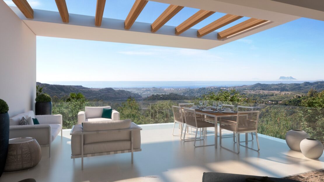 Balcony view with comfortable sofas, lush green landscape, trees, mountains