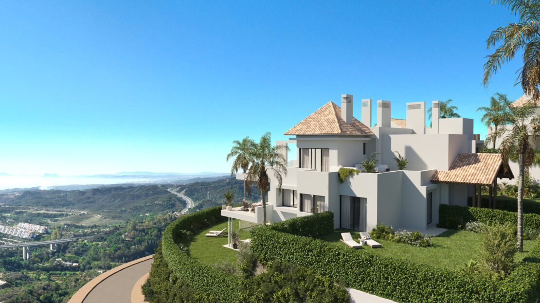 Aerial view of a white villa surrounded by lush greenery, hedges, and beautifully landscaped gardens
