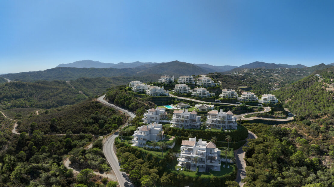 Aerial view of Marbella Club Hills street, showcasing towering white villas with balconies and stunning mountain views